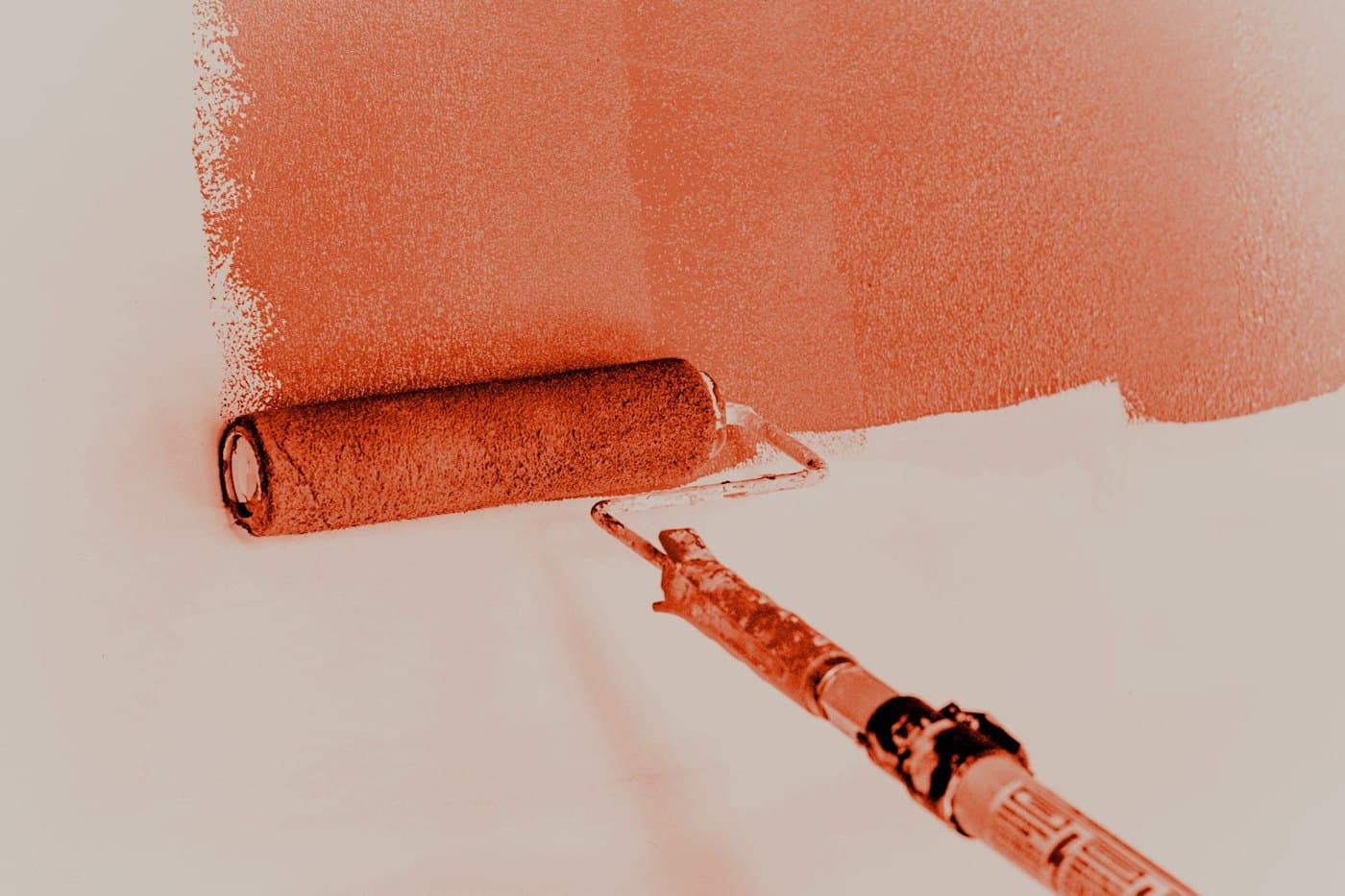 A paint roller on a prepared wall.